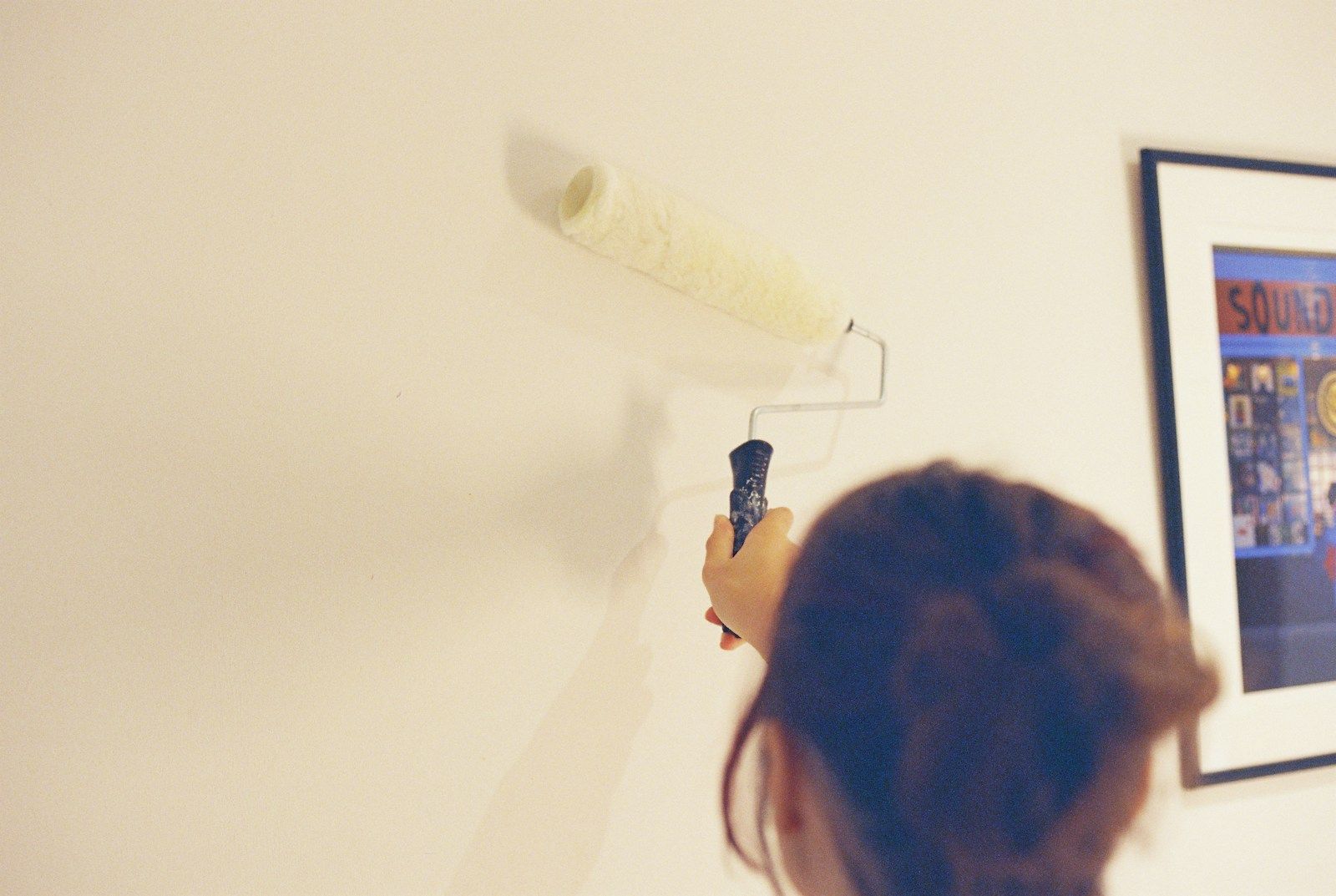 A decorator painting a wall in a home